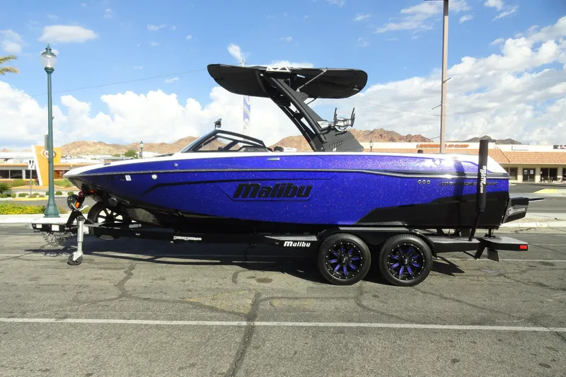 The Image of 2021 Malibu Wakesetter 23 LSV boat on trailer, parked outdoors under a clear sky. - 1