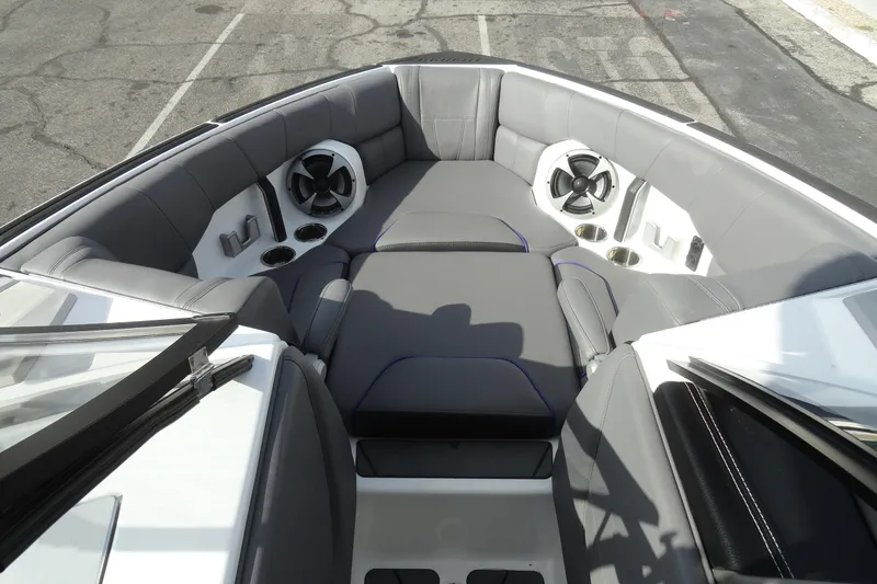 Slide: The Image of 2021 Malibu Wakesetter 23 LSV boat interior with gray seating and built-in speakers. - 18