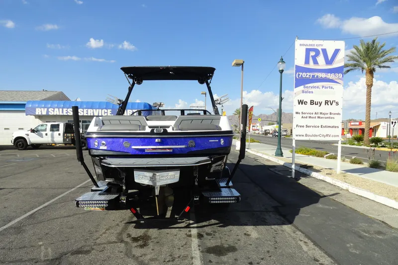 Slide: The Image of 2021 Malibu Wakesetter 23 LSV boat parked at RV sales lot under clear blue sky. - 28