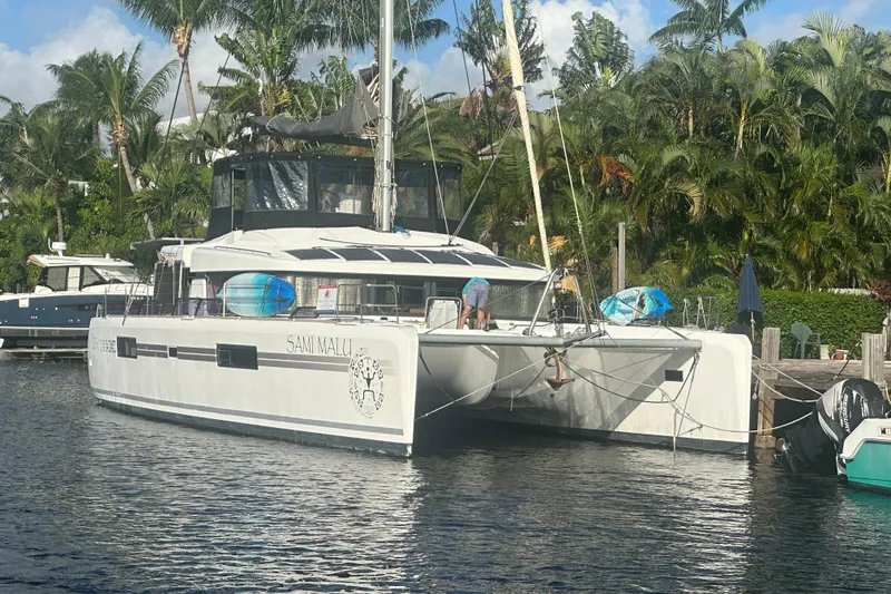 Slide: The Image of 2017 Lagoon 52 F catamaran docked by tropical palm trees. - 0