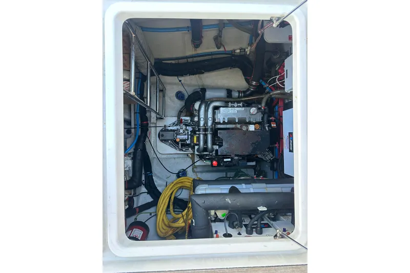 Slide: The Image of 2017 Lagoon 52 F boat docked, featuring an outboard motor and steering console. - 54