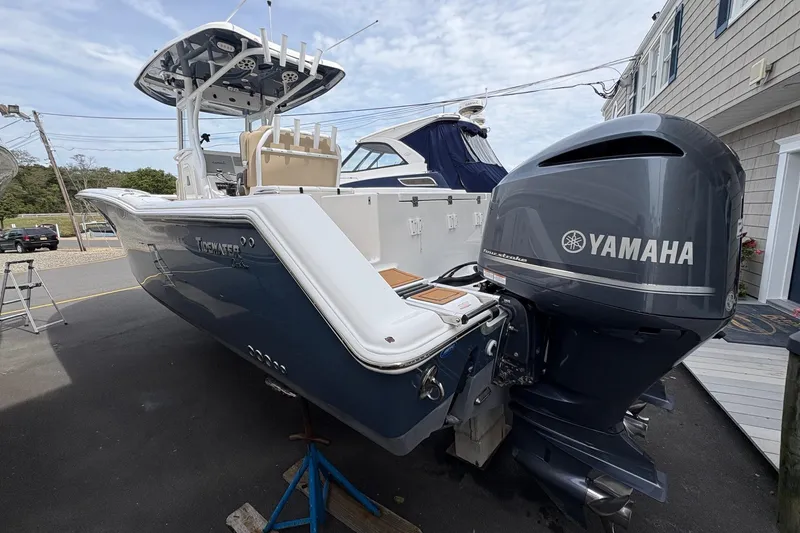 Slide: The Image of 2018 Tidewater 280 CC Adventure boat with dual Yamaha engines docked at a marina. - 11