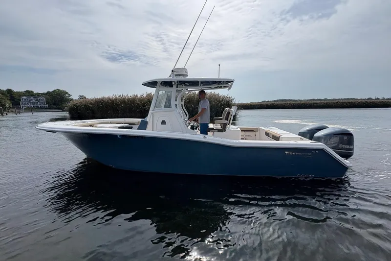 Slide: The Image of 2018 Tidewater 280 CC Adventure boat on calm water, side view. - 2