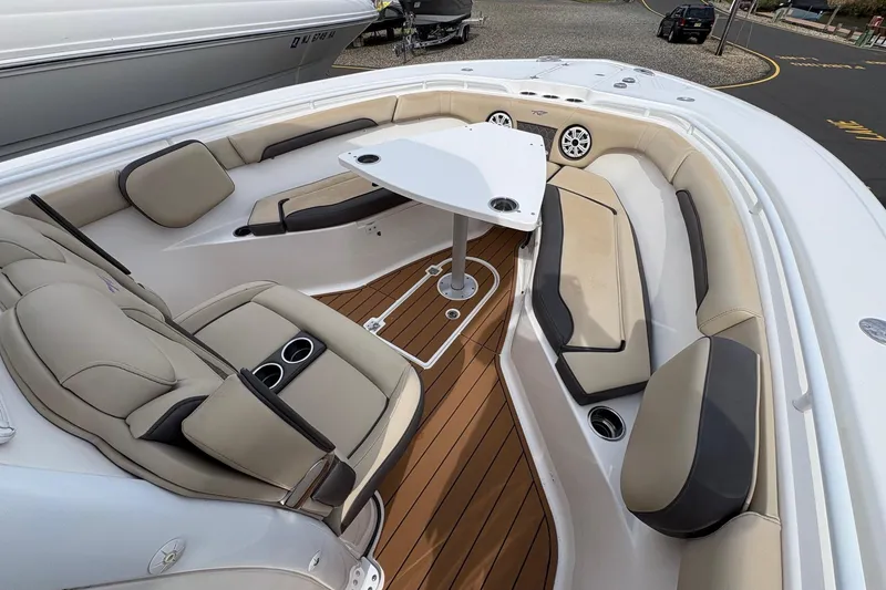 Slide: The Image of 2018 Tidewater 280 CC Adventure boat interior with cushioned seating and table. - 22