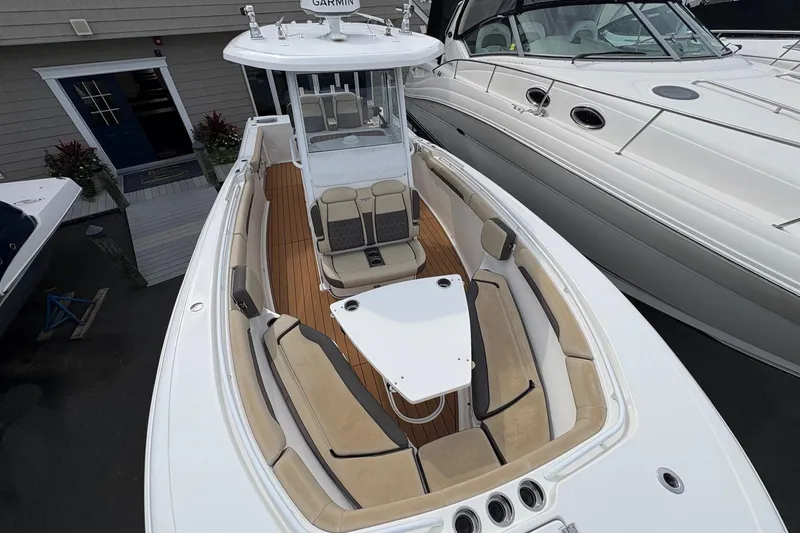 Slide: The Image of 2018 Tidewater 280 CC Adventure boat interior with cushioned seating and table. - 23