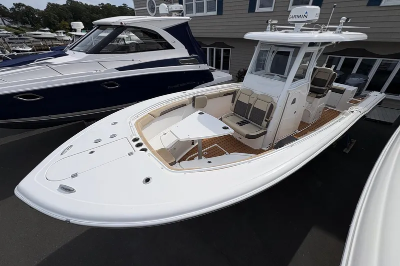 Slide: The Image of 2018 Tidewater 280 CC Adventure boat displayed at a marina, featuring a sleek blue hull. - 7