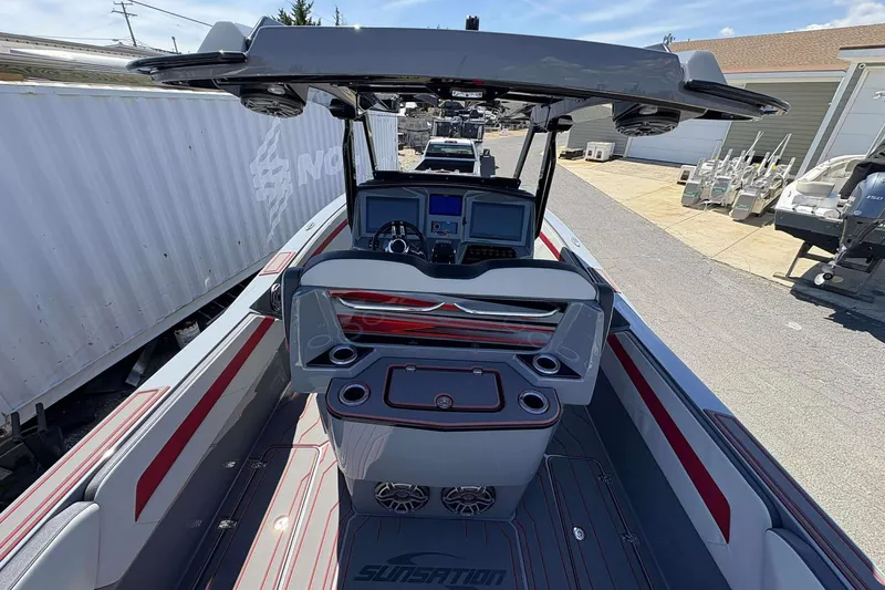 Slide: The Image of 2026 Sunsation 32 CCX boat interior with modern dashboard and seating, docked outdoors. - 30