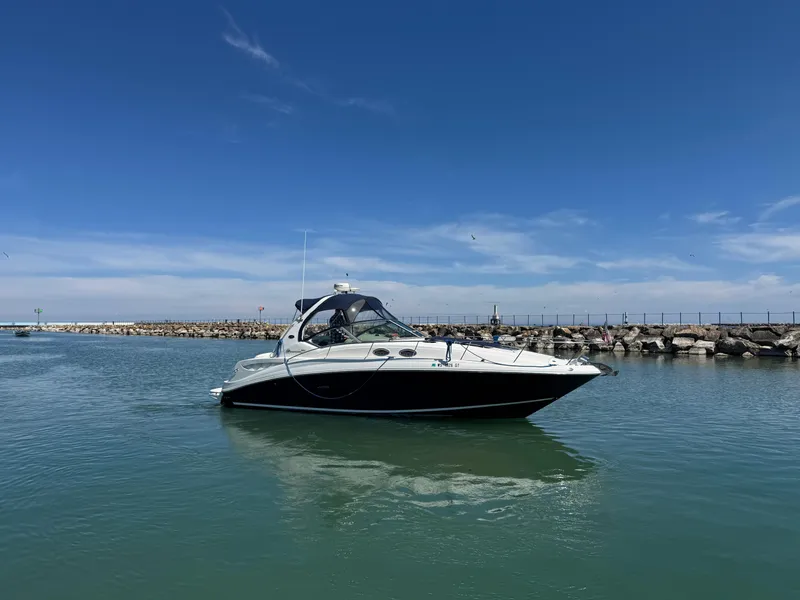 Slide: The Image of 2004 Sea Ray 320 Sundancer boat on calm water under clear blue sky. - 15