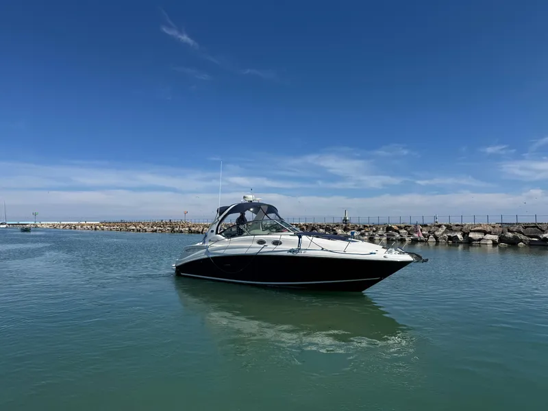 Slide: The Image of 2004 Sea Ray 320 Sundancer boat on calm water under clear blue sky. - 16