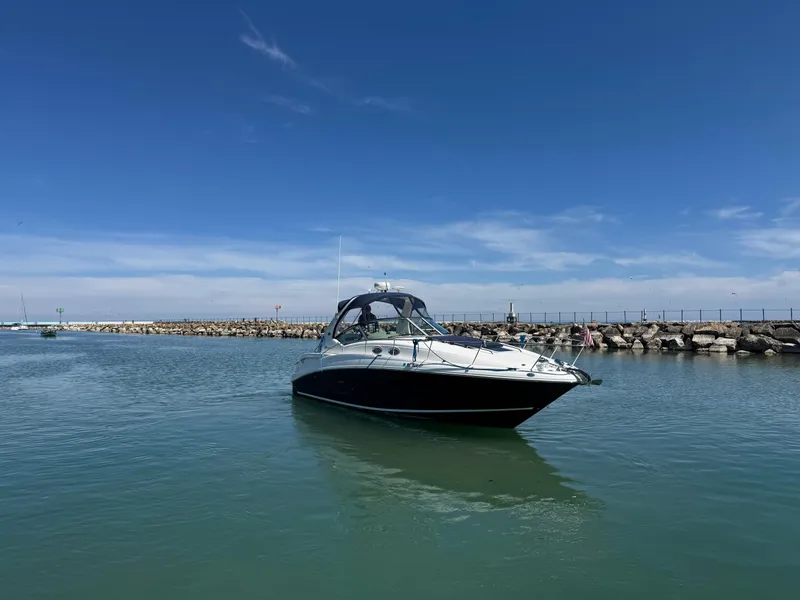 Slide: The Image of 2004 Sea Ray 320 Sundancer boat on calm water under clear blue sky. - 17
