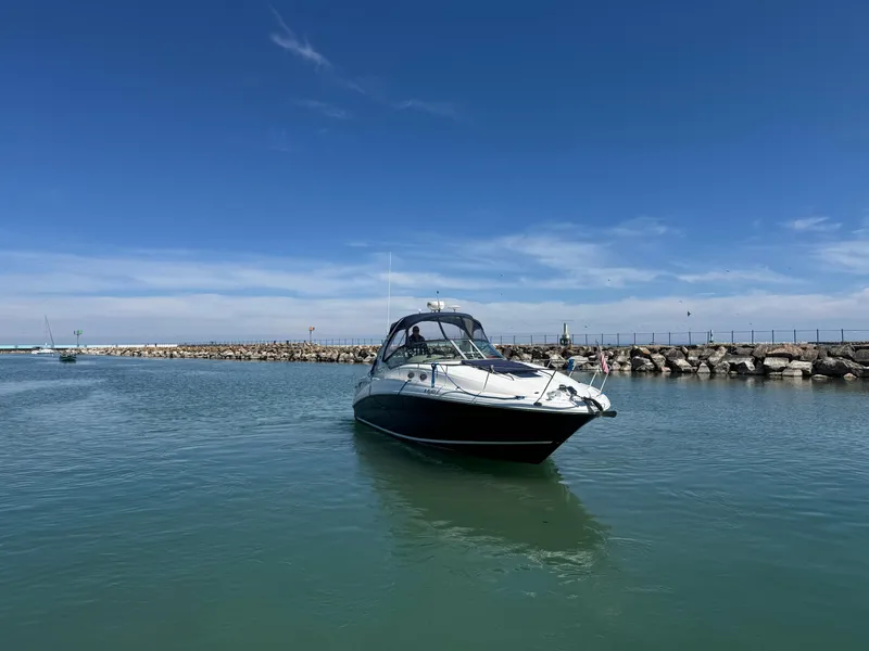 Slide: The Image of 2004 Sea Ray 320 Sundancer boat on calm water under clear blue sky. - 18