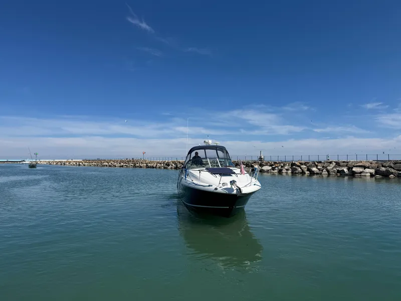 Slide: The Image of Sea Ray 320 Sundancer 2004 cruising in a calm harbor under a clear blue sky. - 19