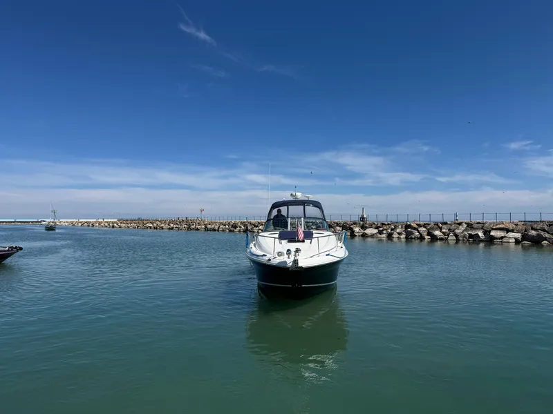Slide: The Image of 2004 Sea Ray 320 Sundancer boat on calm water under clear blue sky. - 20
