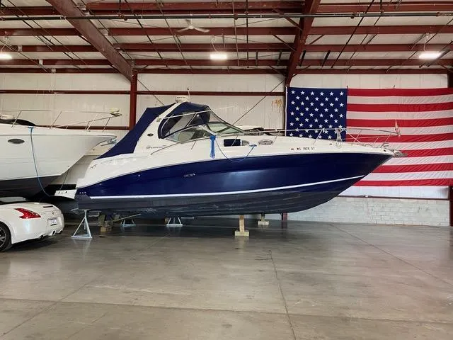 Slide: The Image of 2004 Sea Ray 320 Sundancer boat in warehouse with American flag backdrop. - 21