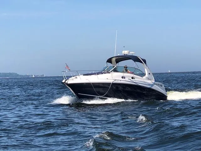 Slide: The Image of 2004 Sea Ray 320 Sundancer cruising on open water under clear blue skies. - 22