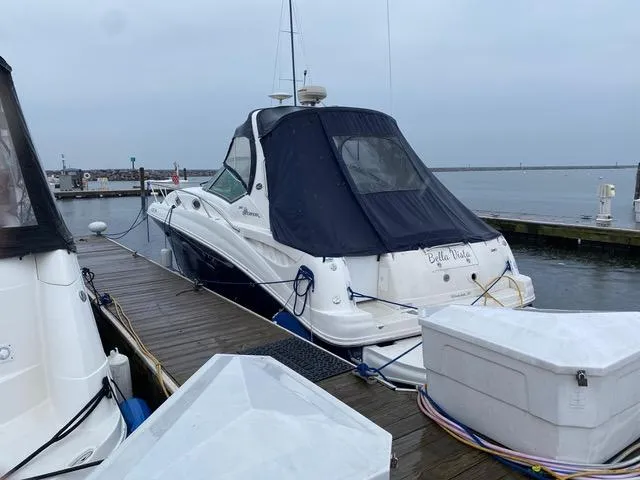 Slide: The Image of 2004 Sea Ray 320 Sundancer docked at marina, covered in navy canvas. - 25