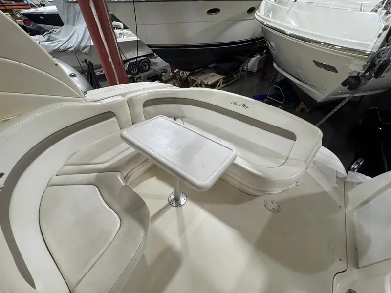 Slide: The Image of 2004 Sea Ray 320 Sundancer boat interior with seating and table in a marina. - 27