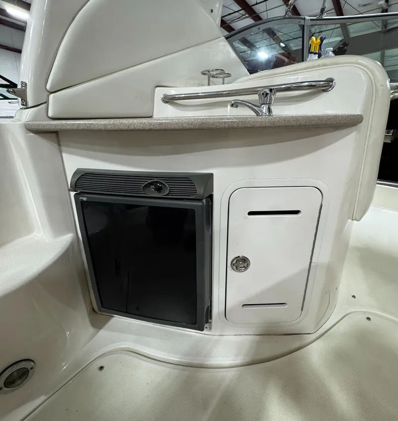 Slide: The Image of 2004 Sea Ray 320 Sundancer boat kitchenette with sink and storage compartments. - 28