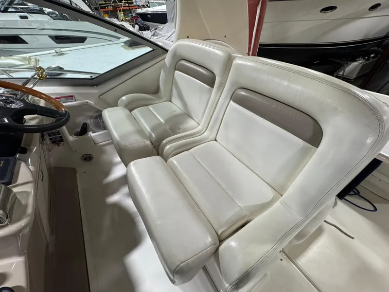 Slide: The Image of 2004 Sea Ray 320 Sundancer cockpit with dual white leather seats. - 32
