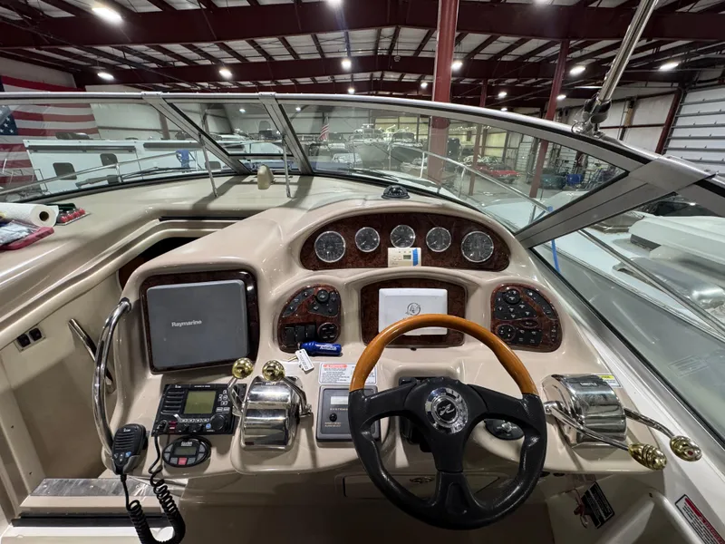 Slide: The Image of 2004 Sea Ray 320 Sundancer helm with steering wheel, gauges, and navigation equipment. - 33