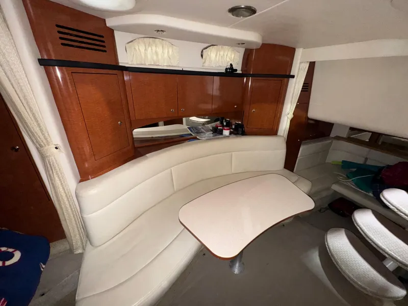 Slide: The Image of 2004 Sea Ray 320 Sundancer cabin with curved seating and wooden cabinetry. - 39