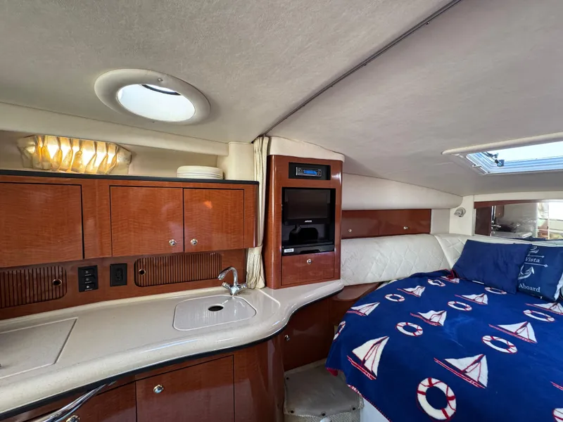 Slide: The Image of 2004 Sea Ray 320 Sundancer cabin with kitchenette and cozy sleeping area. - 41