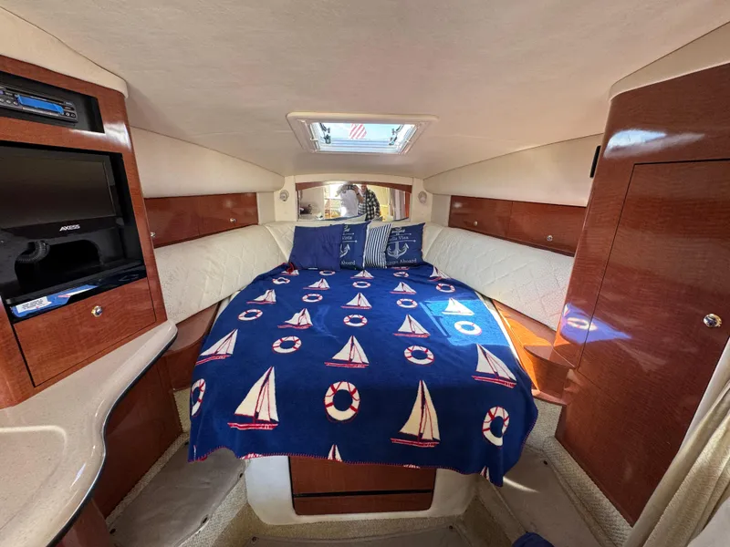 Slide: The Image of Interior cabin of a 2004 Sea Ray 320 Sundancer with nautical-themed bedding. - 43
