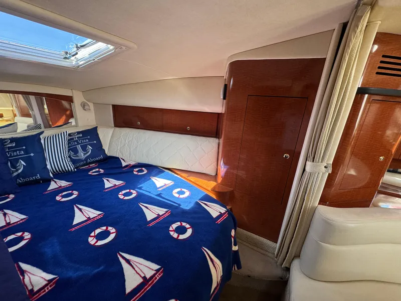 Slide: The Image of Luxurious cabin interior of 2004 Sea Ray 320 Sundancer with nautical-themed bedding. - 44