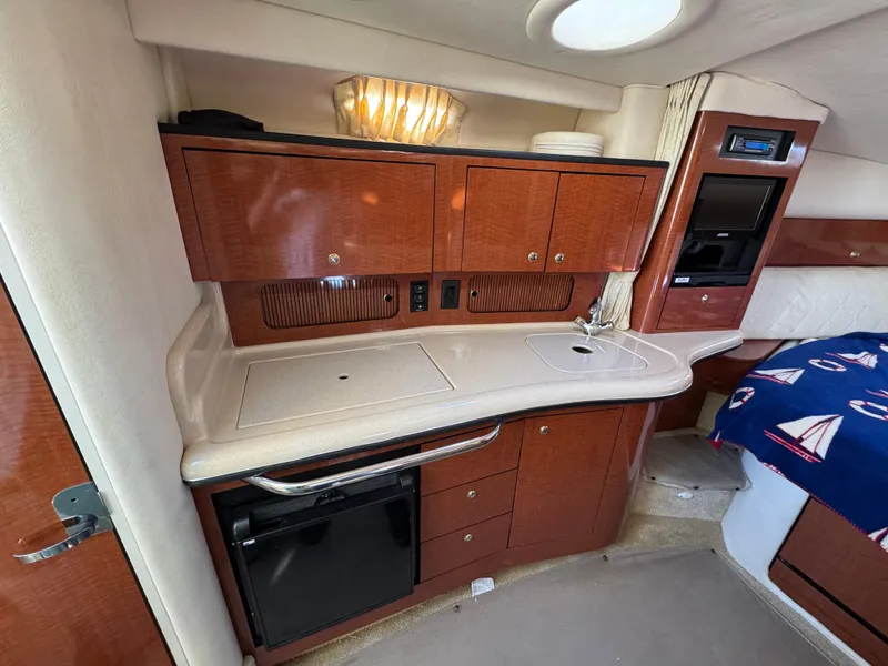 Slide: The Image of 2004 Sea Ray 320 Sundancer cabin interior with kitchenette and wood cabinetry. - 45