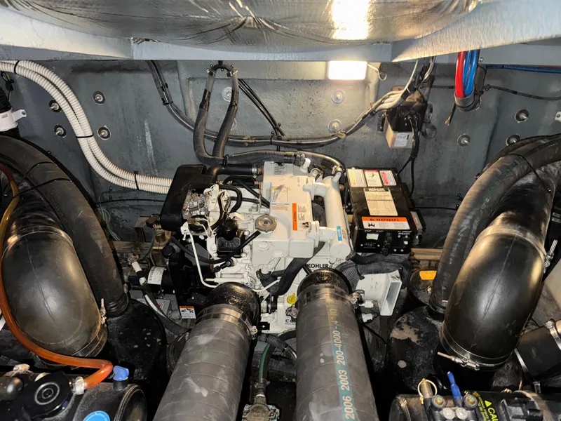 Slide: The Image of Engine compartment of a 2004 Sea Ray 320 Sundancer boat, featuring mechanical components and wiring. - 48