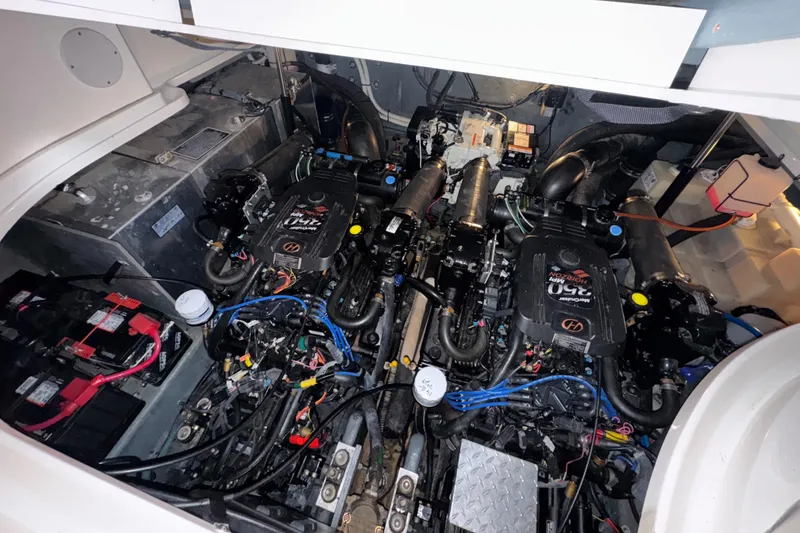 Slide: The Image of Engine compartment of a 2004 Sea Ray 320 Sundancer boat, showcasing dual engines and wiring. - 49