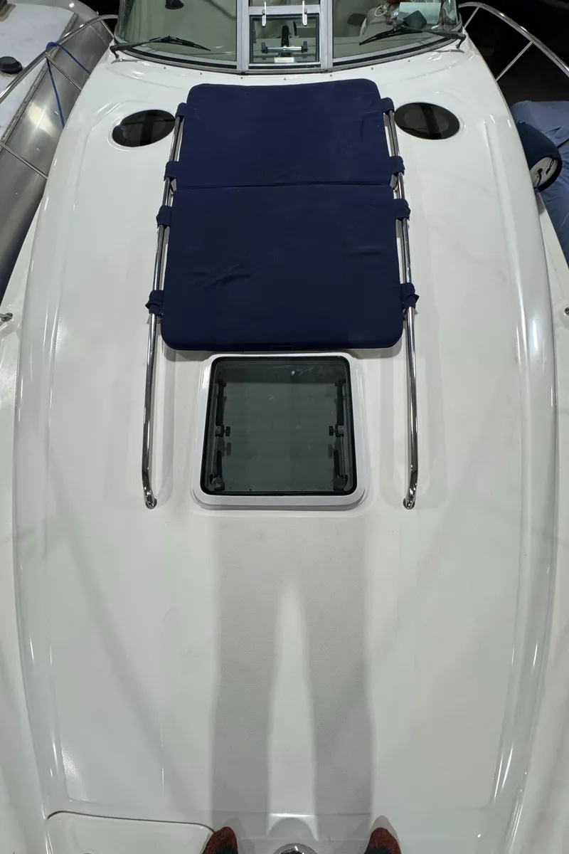 Slide: The Image of 2004 Sea Ray 320 Sundancer boat deck with blue sunpad and hatch. - 64