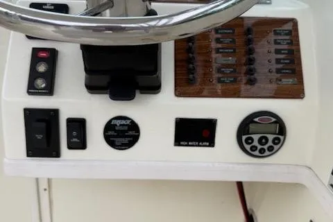 Slide: The Image of Control panel of a 2005 Albemarle 248 Express Fisherman boat with steering wheel and switches. - 12