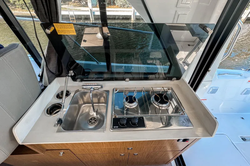 Slide: The Image of Compact kitchen area on 2025 Beneteau Antares 9 boat with stove and sink. - 12