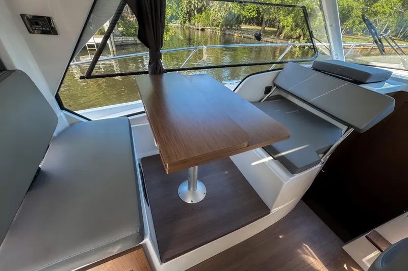 Slide: The Image of Interior of 2025 Beneteau Antares 9, featuring a sleek dining area with a wooden table. - 16