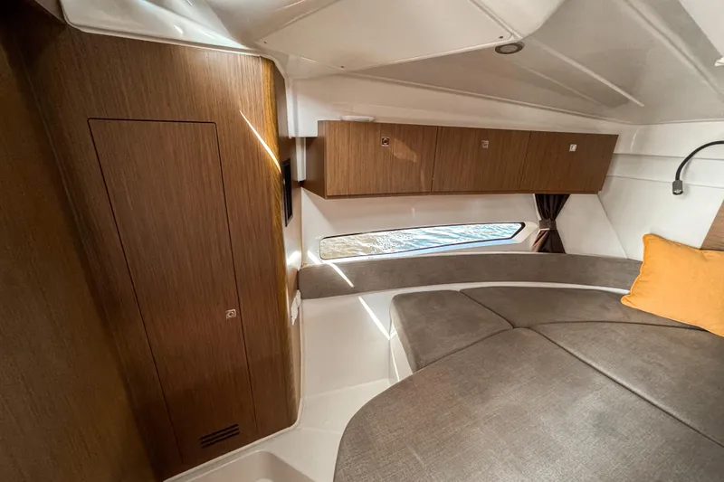 Slide: The Image of 2025 Beneteau Antares 9 cabin interior with wood finish and cozy seating area. - 21