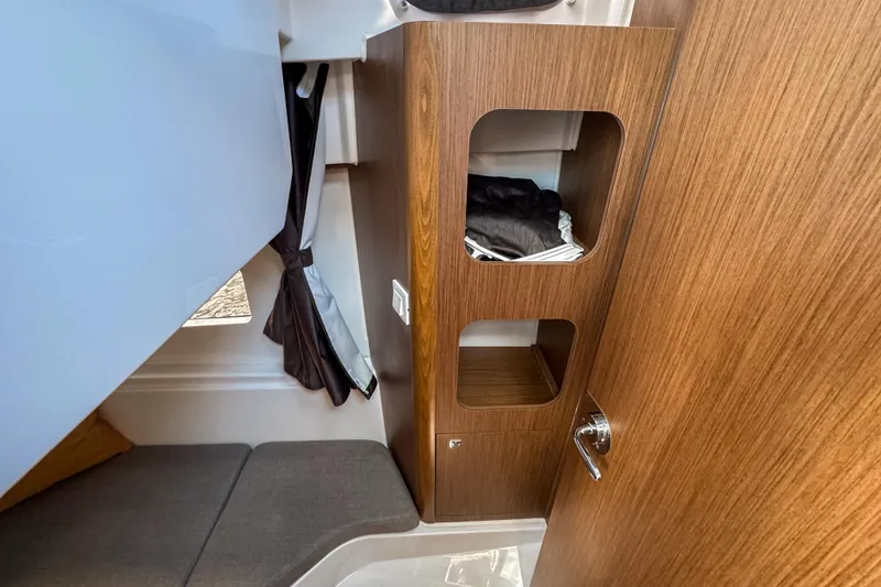 Slide: The Image of Interior of 2025 Beneteau Antares 9, featuring wooden cabinetry and seating area. - 23
