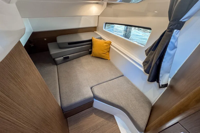Slide: The Image of 2025 Beneteau Antares 9 cabin interior with cozy seating and window view. - 24