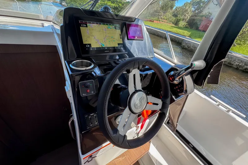 Slide: The Image of 2025 Beneteau Antares 9 helm with navigation display and steering wheel. - 7