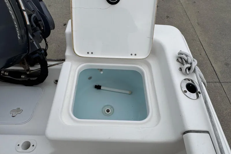 Slide: The Image of 2015 Tidewater 1800 Bay Max boat livewell with open lid and visible water. - 7