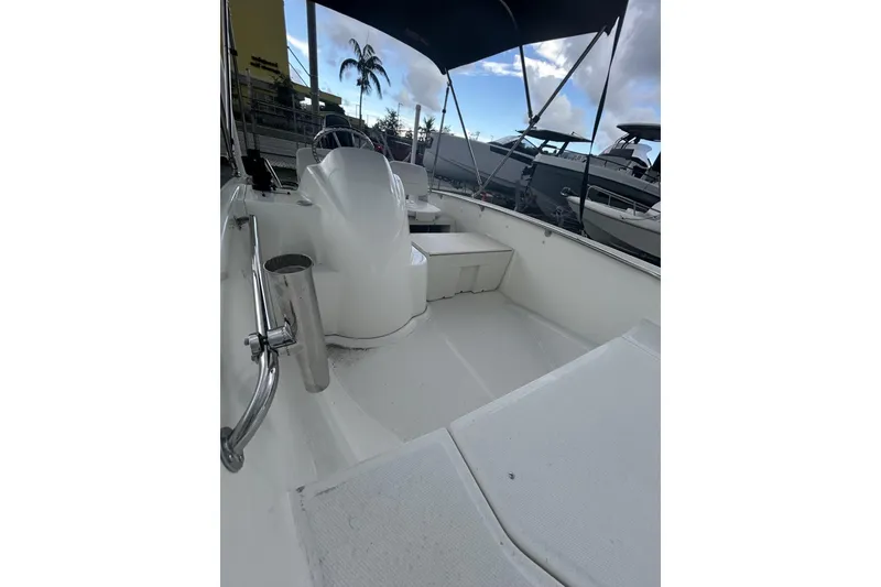 Slide: The Image of 2011 Boston Whaler 160 Super Sport interior with seating and canopy, docked near other boats. - 16