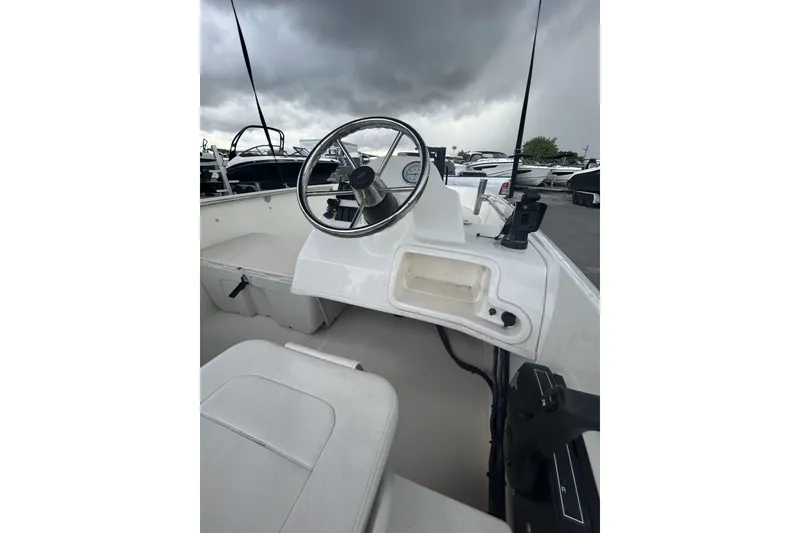 Slide: The Image of 2011 Boston Whaler 160 Super Sport boat interior with steering wheel and controls. - 17