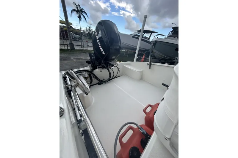 Slide: The Image of 2011 Boston Whaler 160 Super Sport boat with Mercury engine, docked outdoors. - 19
