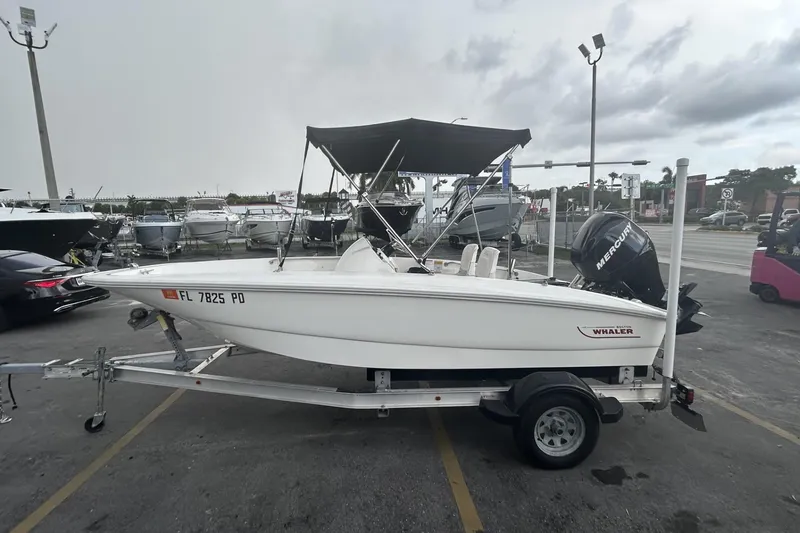 Slide: The Image of 2011 Boston Whaler 160 Super Sport boat on trailer, parked in marina lot. - 2