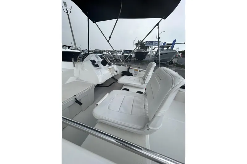 Slide: The Image of 2011 Boston Whaler 160 Super Sport interior with white seating and steering console. - 21