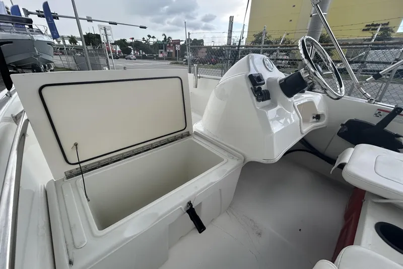 Slide: The Image of 2011 Boston Whaler 160 Super Sport interior with open storage compartment and steering console. - 22