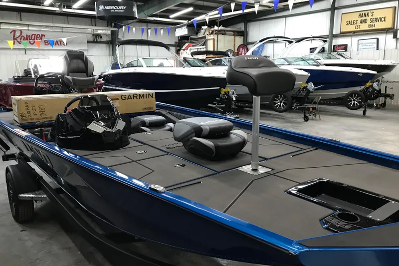 Slide: The Image of 2026 Lund 1875 Renegade boat in showroom, featuring sleek design and modern equipment. - 12