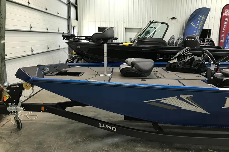 Slide: The Image of 2026 Lund 1875 Renegade boat with Mercury Pro XS engine in a garage setting. - 9