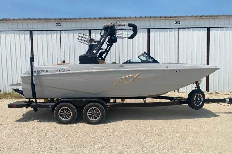 The Image of 2026 ATX Surf Boats 20 Type-S on trailer, parked outside storage units. - 0