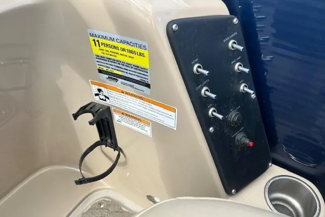 Slide: The Image of Control panel of 2014 Manitou 24 Oasis SR boat with capacity and warning labels. - 12